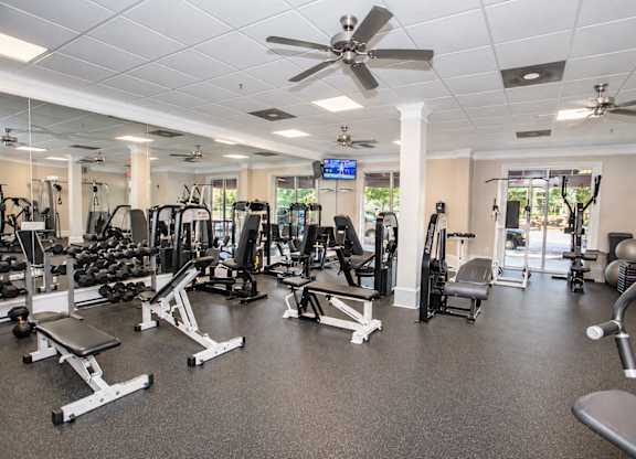 A spacious gym with a variety of equipment including treadmills, weights, and exercise machines.