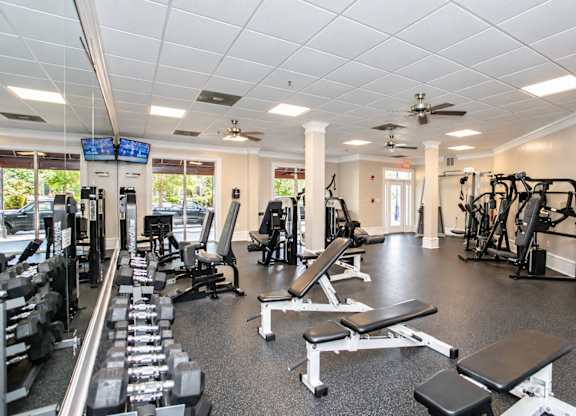 A gym with a variety of equipment including weights and cardio machines.
