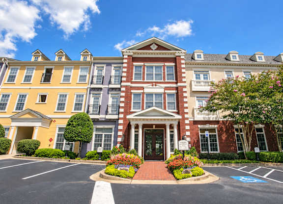 A large, multi-story building with a red brick facade and a white entrance.