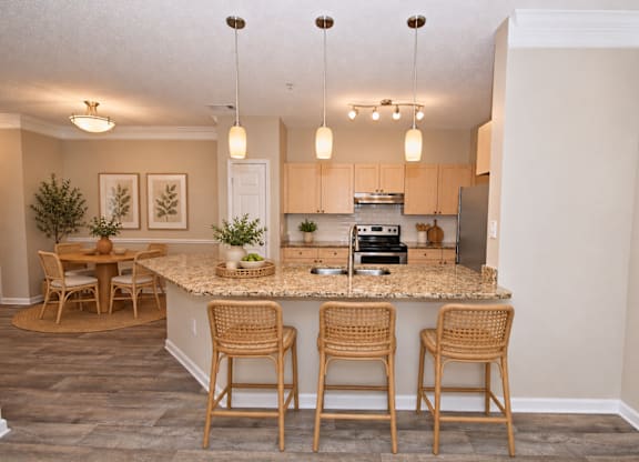A kitchen with a bar area and chairs.