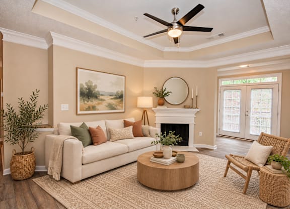 A living room with a fireplace, a couch, a chair, and a ceiling fan.
