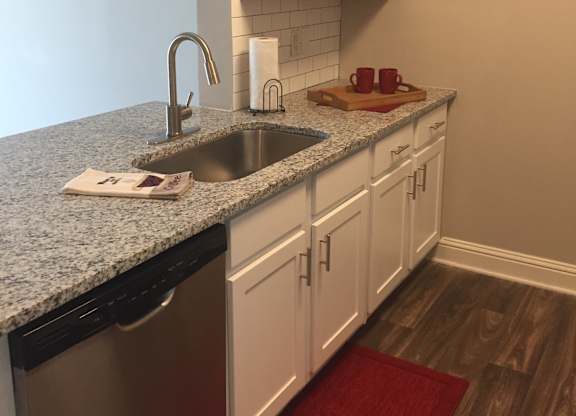 a kitchen with white cabinets and a granite counter top at Lullwater at Calumet, Newnan