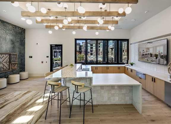 A modern kitchen with a large island and bar stools.