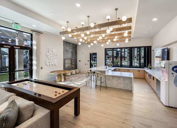 A modern kitchen with a pool table in the middle.