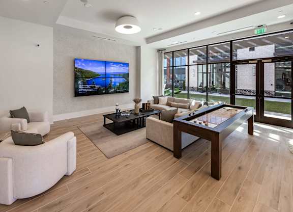 A modern living room with a flat screen TV mounted on the wall.