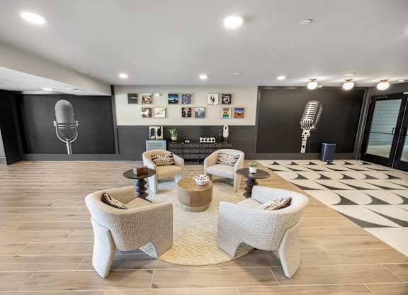 A modern living room with a large speaker and a collection of framed pictures on the wall.