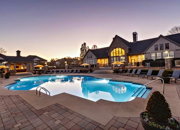 A large swimming pool in a backyard with a house in the background.