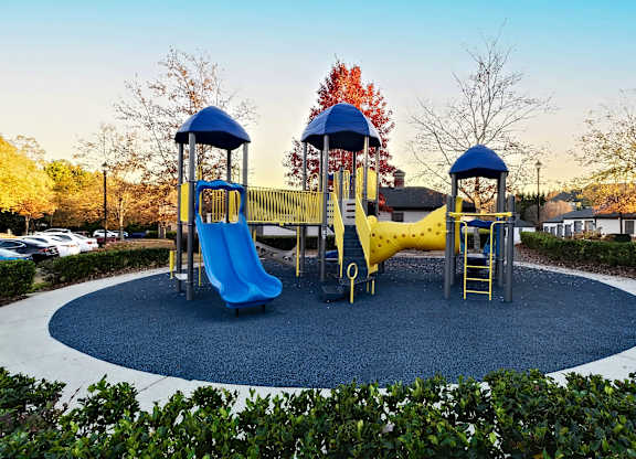 A playground with a blue slide and yellow slide.