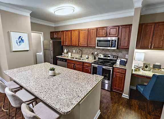 A kitchen with a granite countertop and wooden cabinets.