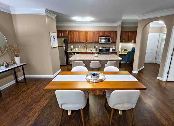 A kitchen with a table and chairs in the foreground.