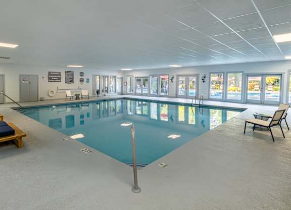a large indoor swimming pool with lounge chairs and tables at Seven Pines, Alpharetta, GA