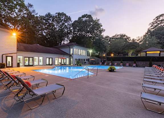 a swimming pool with chaise lounge chairs and a building in the background at Seven Pines, Alpharetta, GA
