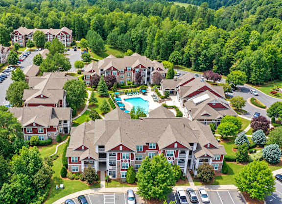 A bird's eye view of a residential area with houses and a swimming pool.