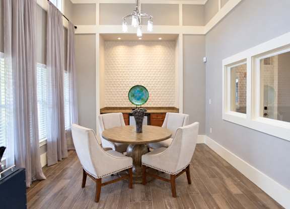 A dining room with a round table and chairs.