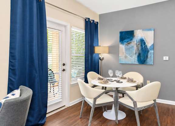 A dining room with a table set for four.
