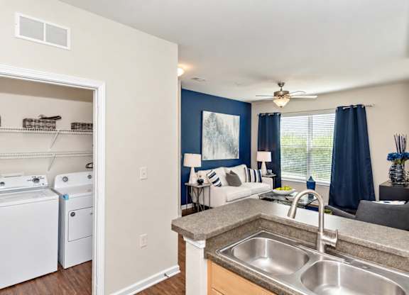 A kitchen with a washer and dryer in the laundry room.