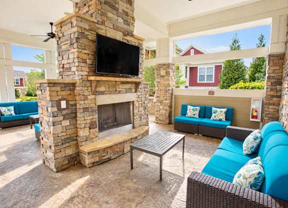 A stone fireplace with a flat screen TV above it.