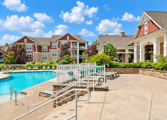 A pool area with a slide and a building in the background.