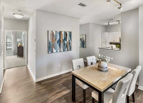 A dining room with a wooden table and chairs.