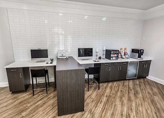 A modern home office with a wooden desk and chairs.