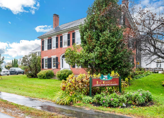 a red brick building with a sign in front of it