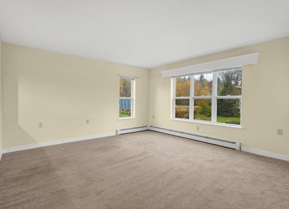 the living room of an empty house with a large window