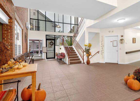 the living room with pumpkins on the floor and a staircase