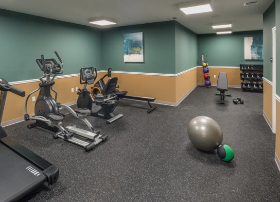 a gym with exercise equipment and a ball on the floor at Eden & Main 55+ Apartments, Southington , Connecticut