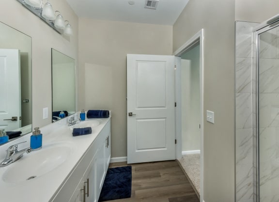 a bathroom with a shower and a sink and a mirror at Eden & Main 55+ Apartments, Southington