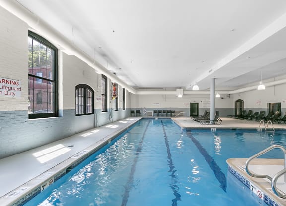 a swimming pool in a building with a blue water floor and at Clocktower and Velvet Mill Apartments, Connecticut
