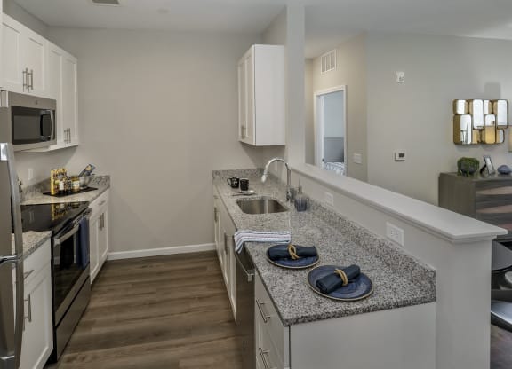 a kitchen with granite counter tops and stainless steel appliances at Eden & Main 55+ Apartments, Connecticut, 06489