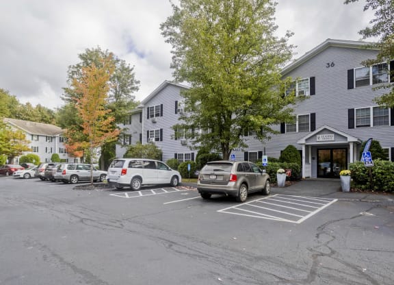 a parking lot with cars in front of an apartment building