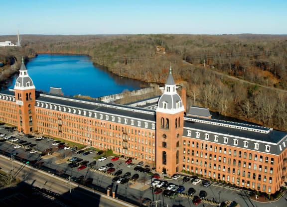 an aerial view of a large building next to a river at Ponemah Mills in Taftville, CT, 06380