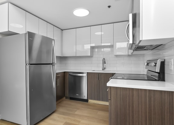 a kitchen with white cabinets and a stainless steel refrigerator at 1188 Lofts, Bridgeport, Connecticut