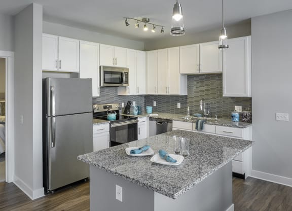 a kitchen with granite counter top and stainless steel refrigerator at The Beacon at Gateway Apartments, Scarborough, ME, 04074