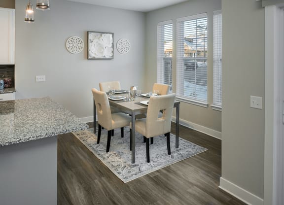 a dining room with a table and chairs and a window at The Beacon at Gateway Apartments, Scarborough, ME, 04074
