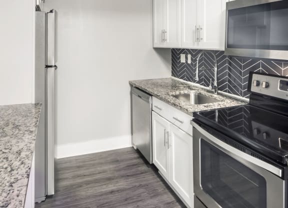 a kitchen with stainless steel appliances and white cabinets at COVE West Hartford, West Hartford, CT