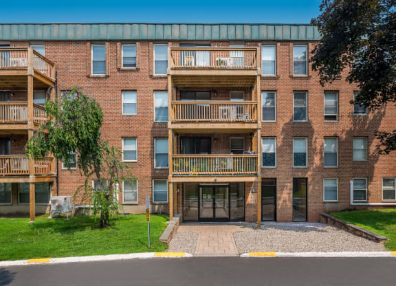 an exterior view of a brick apartment building with balconies at COVE West Hartford, West Hartford, CT