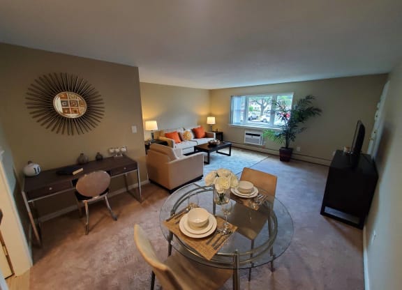 an open living room and dining room with a glass table at Greenfield Village Apartments, Rocky Hill, CT