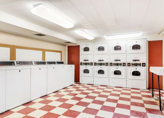 Laundry room with many washers and dryers and a checkered floor at Griswold Gardens in Glastonbury, CT, 06033