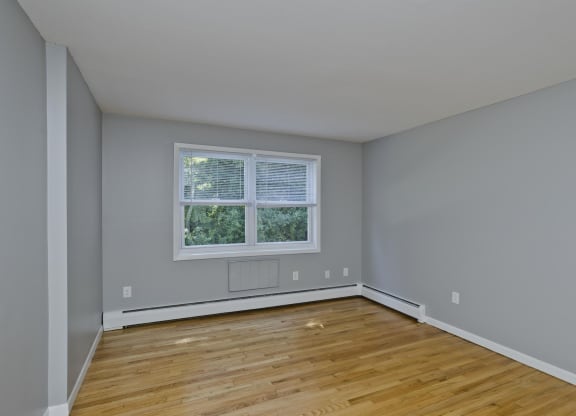 an empty room with wooden floors and a window at Hawkins Meadow in Amherst, MA, 01002