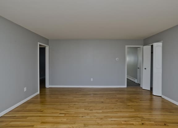 an empty living room with wood floors and grey walls at Hawkins Meadow in Amherst, MA, 01002