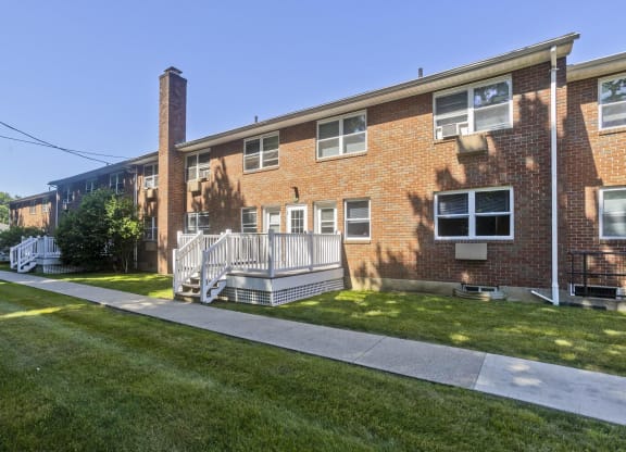 the front of a brick apartment building with a porch and lawn at Hawkins Meadow in Amherst, MA, 01002