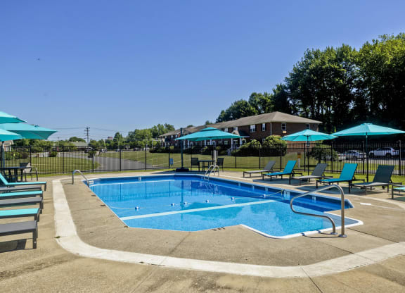 a swimming pool with blue chairs and umbrellas at Hawkins Meadow in Amherst, MA, 01002