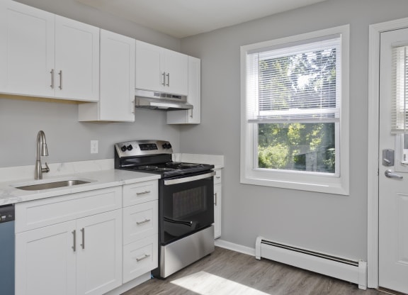 a kitchen with white cabinets and a stove and a window at Laurel Ridge in Northampton, MA, 01060