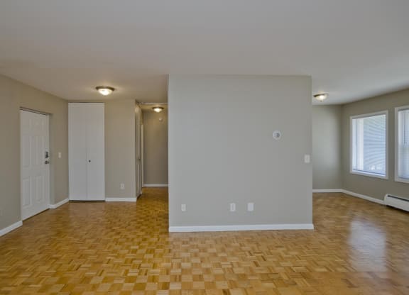 an empty living room with a wooden floor and white walls at Park Edge, Massachusetts, 13502