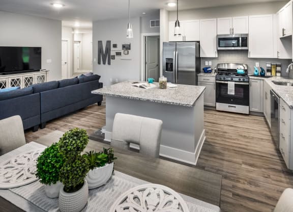 an open kitchen and living room with a table and chairs at The Residences at Crosstree, Freeport, 04096