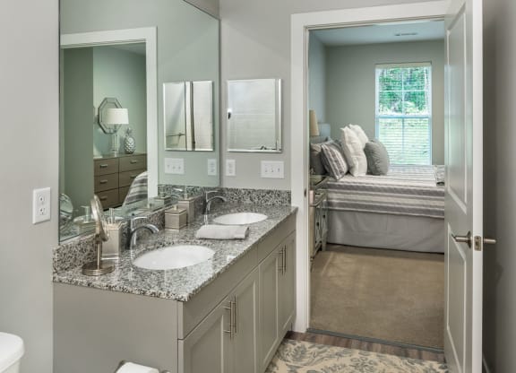 a bathroom with two sinks and a toilet and a mirror at The Residences at Crosstree, Freeport, ME