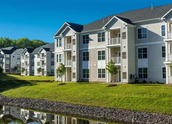 an apartment building with a pond in front of it at The Residences at Crosstree, Freeport, 04096