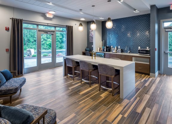 a lobby with a kitchen and a table with chairs at The Residences at Crosstree, Freeport